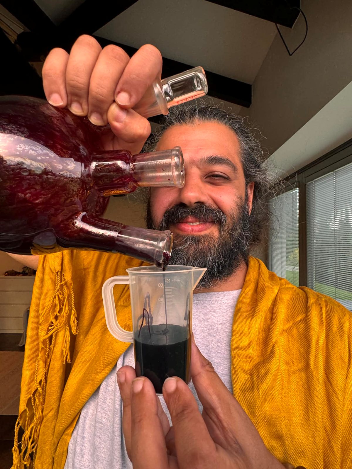 Ali Odeh holding a glass alchemy flask of Blue Lotus extract.