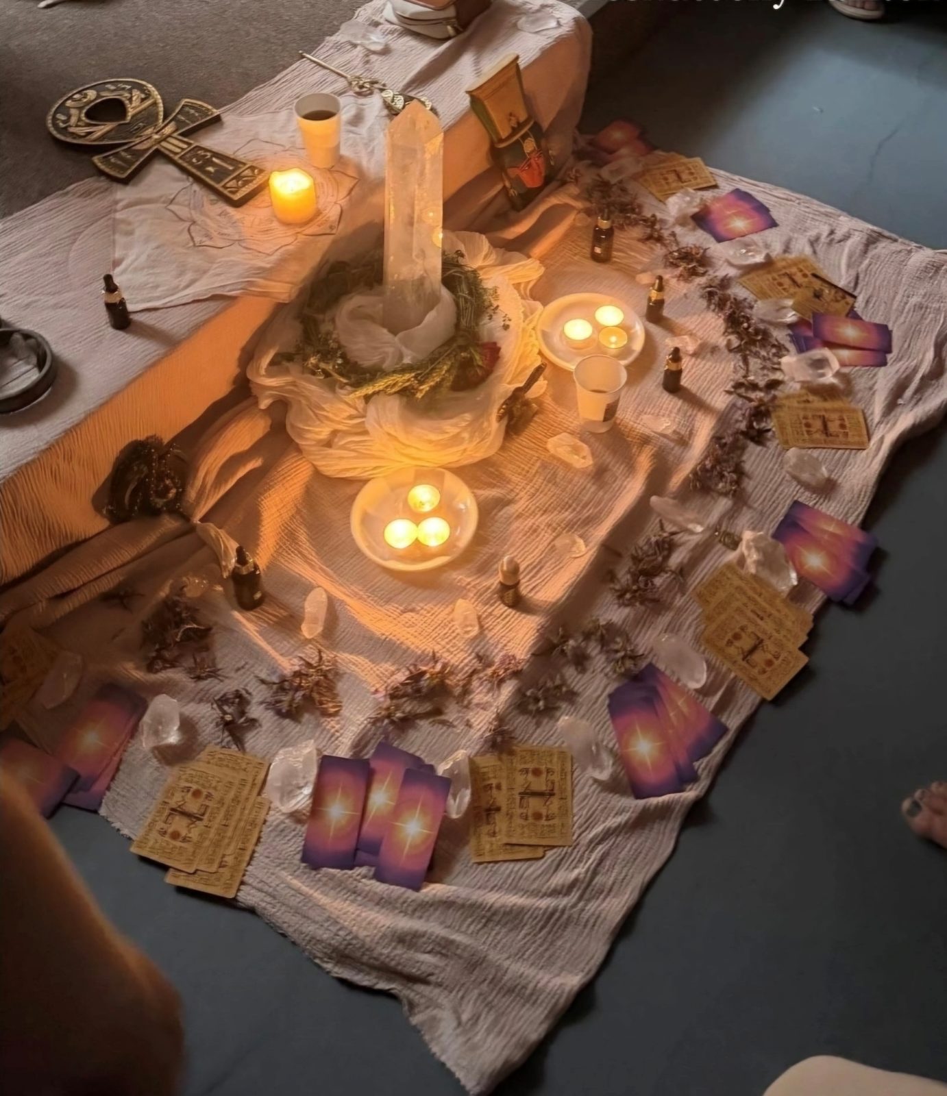 A candlelit altar laid for ceremony, crystals and flowers arranged around it.
